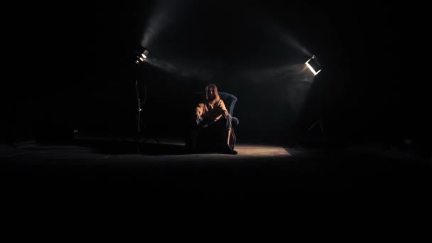 Женщина сидит на стуле в студии — стоковое видео