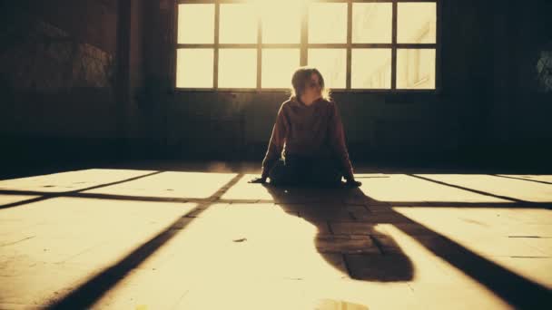 Девушка одна в закрытом помещении. Свет и тень — стоковое видео