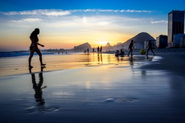 İnsan, Rio de Janeiro, Brezilya siluetleri ile Copacabana plajında güzel gün batımı