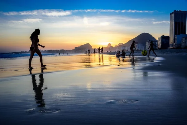 Wunderschöner Sonnenuntergang am Copacabana-Strand mit Menschensilhouetten, Rio de Janeiro, Brasilien — Stockfoto