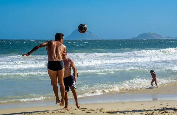 6. prosince 2016. Skákání muž hrát plážový fotbal na pozadí Atlantského oceánu na pláži Copacabana — Stock fotografie