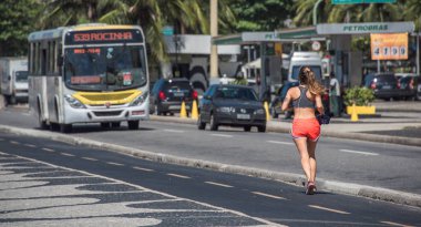 Rio De Janeiro, Brezilya - 31 Ekim 2016: kadın Copacabana Plajı yol trafik yol önünde çalışan beachfront koşu