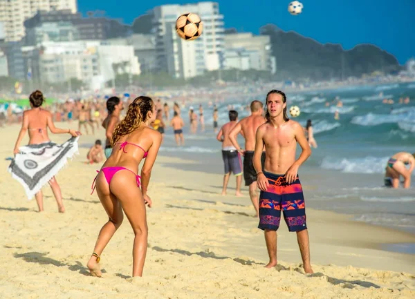 Zadní část brazilské krásná sexy žena v dobrém stavu, hrát plážový fotbal se svými přáteli na Copacabana Beach — Stock fotografie