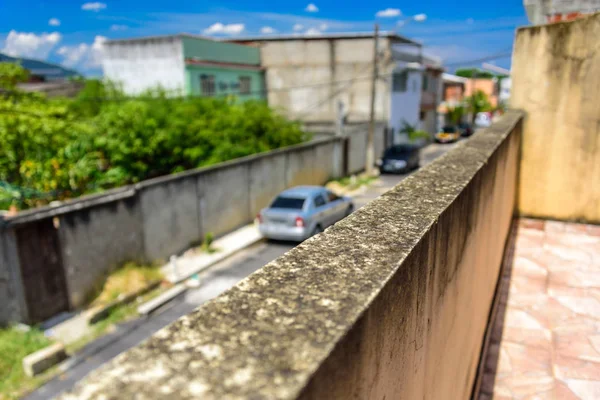 Dinding berjamur dan jalan buram dengan mobil dan rumah penduduk di lingkungan Bangu, Zona Barat Rio de Janeiro — Stok Foto