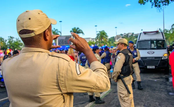 Costas do policial tirando fotos de figurinos na Bloco Orquestra Voadora no Flamengo Park, Carnaval 2017 — Fotografia de Stock