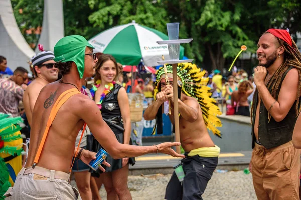 Homem em um traje de indígenas atirando um arco e flecha com ventosa em alvo feito de copos de plástico, Carnaval 2017 — Fotografia de Stock