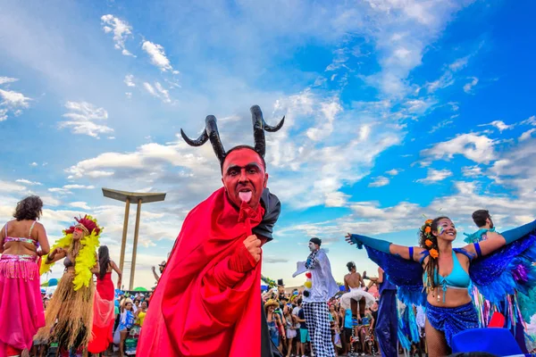 Joven en zancos con un disfraz de diablo lamiéndose la cola en Bloco Orquestra Voadora, Carnaval 2017 — Foto de Stock