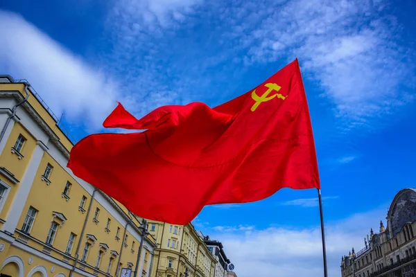 Egy vörös zászlót, a Szovjet Szocialista Köztársaságok a sarló-kalapács a szél integet International dolgozók nap — Stock Fotó