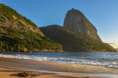 Güzel ıssız Praia Vermelha Beach Sugarloaf dağ aydınlatıcı parlak güneş doğarken