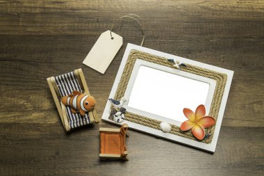 Plaj yatak ve sandalye ve ahşap masa üzerinde fiyat etiketi ile bir fotoğraf çerçevesi