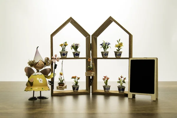 Sarı bebek stand ev çerçeve çiçek ve boş kara tahta ile yakın