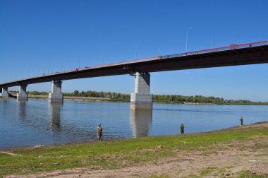 Rusya 'nın Tomsk bölgesindeki büyük Sibirya nehri Ob' u üzerindeki köprüye bakan manzara.