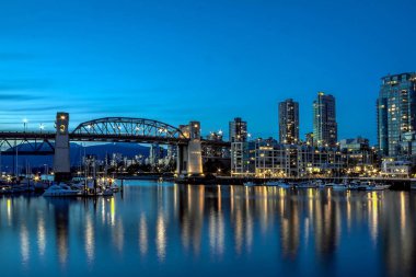 Gün batımında yansımaları şehir ışıkları ayna su koyun. Burrard Köprüsü, şehir şehir Vancouver, British Columbia Kanada