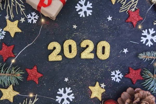 Νέο έτος επίπεδη θέσει 2020. Σε σκούρο φόντο, χρυσαφί γυαλιστεροί αριθμοί 2020 σε γκλίτερ, κλαδιά ερυθρελάτης, χριστουγεννιάτικα παιχνίδια και γιρλάντα. Ελεύθερο spase για κείμενο — Φωτογραφία Αρχείου