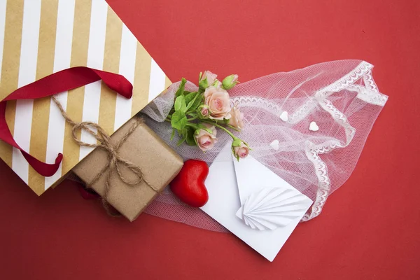 Do saco do presente colocar um presente, um envelope, um coração, flores e — Fotografia de Stock