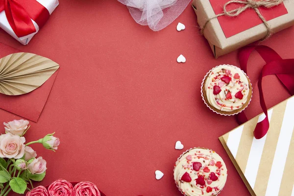 Fundo vermelho com cupcakes, corações, presentes, flores. Espaço livre — Fotografia de Stock