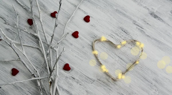 White branches with red hearts and a garland in the shape of a heart — Stock Photo, Image