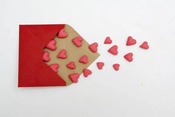 Κόκκινες καρδιές πετούν έξω από ένα φάκελο σε λευκό φόντο. Βαλέντι. — Φωτογραφία Αρχείου