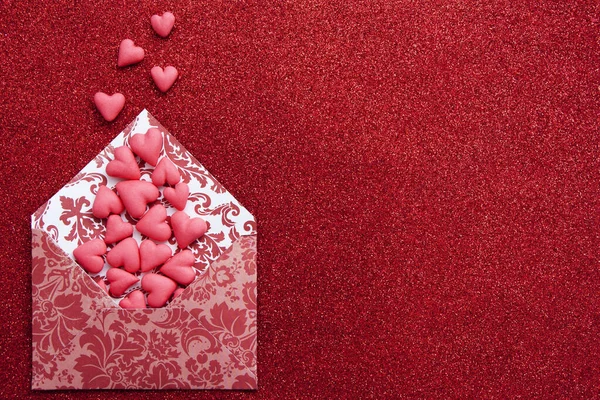 Piros szív repül ki a borítékból egy piros csillogó háttér. — Stock Fotó