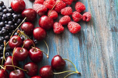 Ahududu, kiraz, boyalı yüzeyde yaban mersini