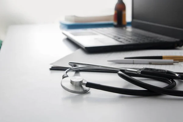 Close-up stethoscope on a white table of a doctor. Workplace of a doctor. Medical concept — 스톡 사진