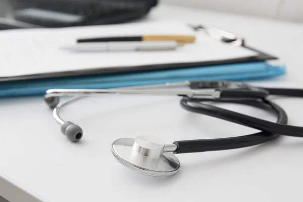 Close-up stethoscope on a white table of a doctor. Workplace of a doctor. Medical concept — 스톡 사진
