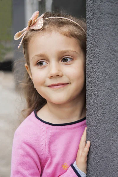 Симпатична дівчинка з обручем посміхається, дивлячись в бік. Портра — стокове фото