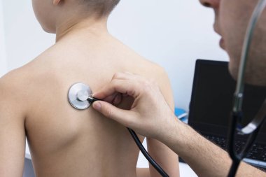 Doktor steteskoplu bir çocuğu dinliyor. Hastalık