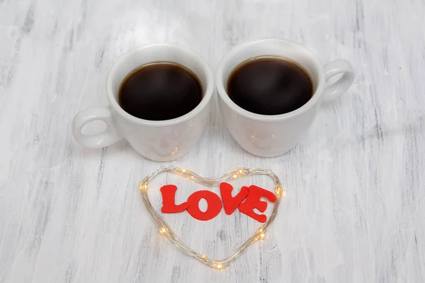 Δύο φλιτζάνια καφέ με την επιγραφή Αγάπη και μια καρδιά σε ένα pa — Φωτογραφία Αρχείου