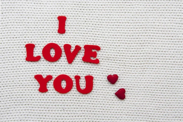 Η επιγραφή σ 'αγαπώ με κόκκινα γράμματα σ' ένα λευκό πλεκτό μπεκ. — Φωτογραφία Αρχείου