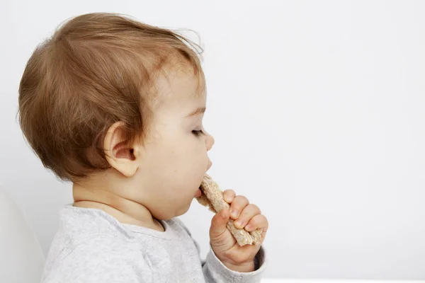 子供は食事パンを食べる。ベビーフードのコンセプト — ストック写真