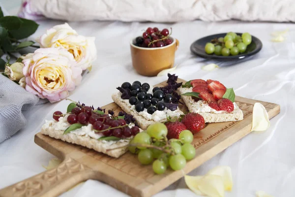 Diet breakfast in bed. Sandwiches with cottage cheese and berrie