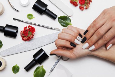Matte black and white manicure on woman's hands. Tools for manic