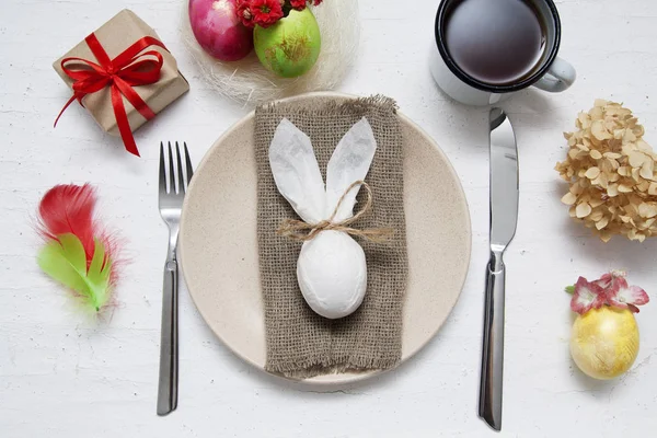 Plate and cutlery with Easter bunny, eggs and feathers. Easter t — Stock Photo, Image