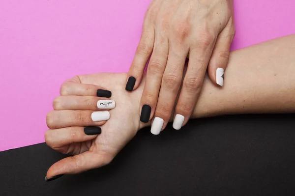 Manicura en blanco y negro en la mano de una mujer en un rosa y negro b — Foto de Stock