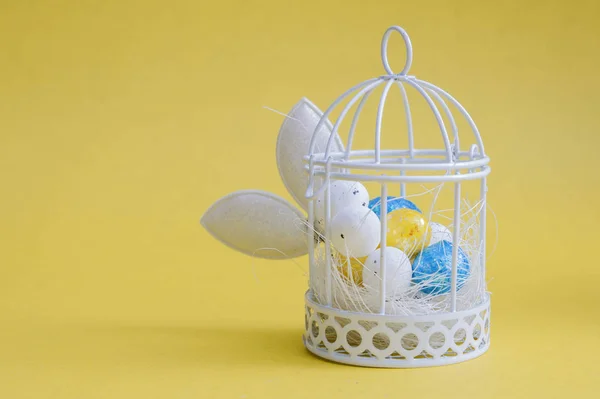 Creatieve Paassamenstelling Van Eieren Een Vogelkooi Konijnenoren Een Gele Achtergrond — Stockfoto