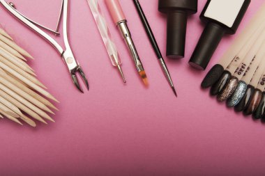 Manikür ve jöle boyası için profesyonel aletler. Pembe arka planda üst manzara. Boşluğu kopyala