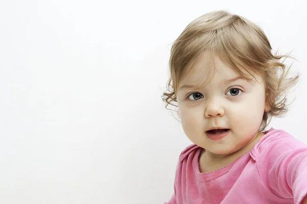 コピースペースと白の赤ちゃんの女の子の肖像画 陽気な女の子見ますザカメラ — ストック写真