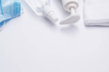 Beyaz arka planda Coronavirus koruması. Sıvı sabun, dezenfektan, tıbbi maske, peçete - virüs kontrol kavramı