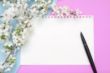 Çiçekli pembe-mavi arkaplanlı boş bir not defteri. Yay metni için boşluk kopyala.