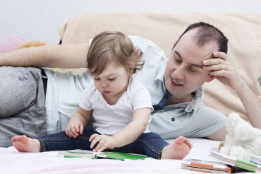 Baba ve kızı kitapları düşünüyor. Babalar Günü konsepti. Çocuklarla evde oyunlar ve aktiviteler