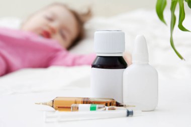 Şurup, uyuyan bir çocuğun arka planına karşı burun ve ampuller için damla. Bebek bakımı kavramı