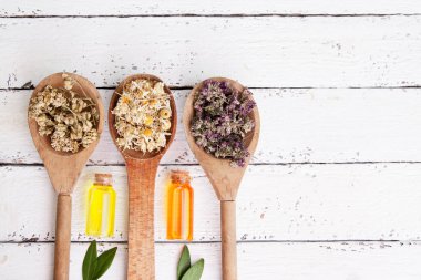 Kurumuş şifalı bitkilerle ahşap kaşıklar ve esanslı şişeler. Alternatif ilaç olarak tıbbi çay ve tentürler.