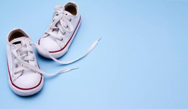 Mavi arka planda bebek ayakkabıları. Bebek ayakkabıları, giysileri, yürüyüşleri ile ilgili mesajlar için boşluk kopyala. Pankart