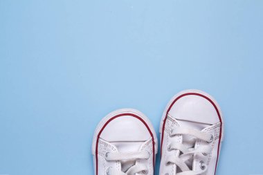 Mavi arka planda çocuk ayakkabıları. Çocuk ayakkabıları, giysileri, yürüyüşleri ile ilgili metinler için boşluk kopyala.
