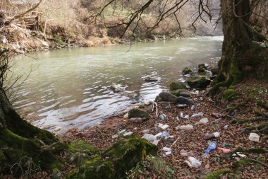 Baile Tusnad, Romania - Nov 28, 2019:  Environmental pollution. Plastic, glass and metal waste in the Olt River in Baile Tusnad , Transylvania, Romania. 