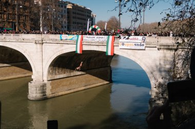 Rome, Italy - Jan 1, 2020: Giuseppe Palmulli  dives into the Tiber River from the 18 meter (59 feet) high Cavour Bridge in Rome