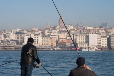 İstanbul, Türkiye - 10 Ocak 2020: İstanbul 'un Beyoğlu ilçesinde, Galata Köprüsü yakınlarındaki Eminonu ilçesinde, Golden Horn' da balıkçılar. Türkiye