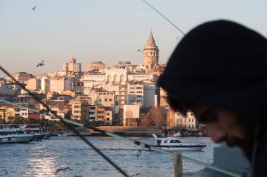 İstanbul, Türkiye - 10 Ocak 2020: Galata Köprüsü 'ndeki balıkçılar, Eminonu, Galata Köprüsü' nün arka planında yer alıyor. Türkiye