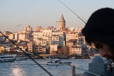 İstanbul, Türkiye - 10 Ocak 2020: Galata Köprüsü 'ndeki balıkçılar, Eminonu, Galata Köprüsü' nün arka planında yer alıyor. Türkiye